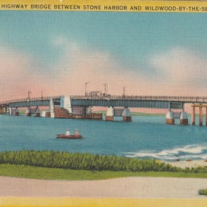 Puede incluir: Postal vintage que muestra el puente New Coastal Highway entre Stone Harbor y Wildwood-by-the-Sea, N.J. El puente cruza agua azul, con un peque&ntilde;o bote y una costa visible. El cielo transiciona de rosa a azul.
