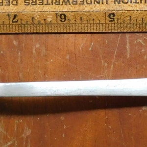 May include: A silver fork with three tines and a heart-shaped handle. The fork is about 8 inches long.