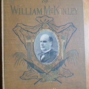 May include: A book cover with a gold embossed title "Illustrious Life of William McKinley Our Martyred President". A portrait of William McKinley is featured in a gold oval frame.