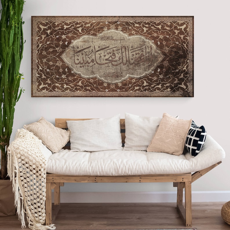May include: A brown wooden canvas print with intricate floral patterns and Arabic calligraphy in a white oval frame. The print has a distressed, vintage look.