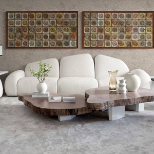 May include: A white sofa with a wooden coffee table in a modern living room. The coffee table has a unique, natural edge design. Two framed pieces of art hang on the wall behind the sofa. The art features a pattern of squares with intricate designs.