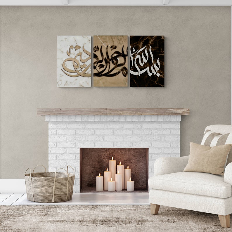 May include: Three framed canvas prints with Arabic calligraphy in black and gold on a marble background. The prints are hung above a white brick fireplace with candles inside.