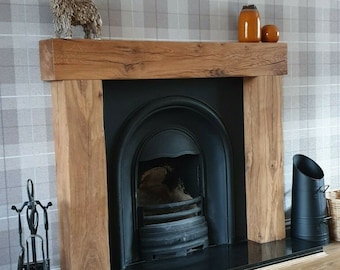 May include: A black fireplace with a wooden mantel and a black hearth. The fireplace has a black metal grate and a black metal firebox. There are two orange ceramic vases on the mantel, and a small brown ceramic animal figurine.