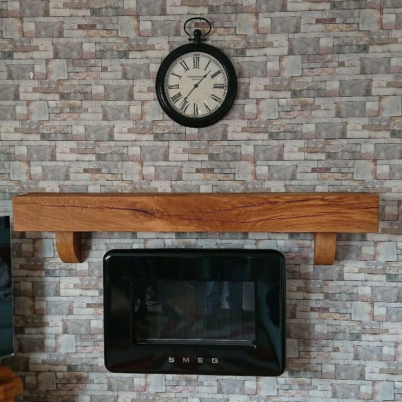 May include: A wooden shelf with a black Smeg oven underneath. The shelf is mounted on a brick wall with a vintage clock above it.