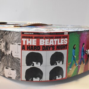 May include: A custom-made acoustic guitar featuring a Beatles theme. The body of the guitar is covered in album covers, including "A Hard Day's Night".