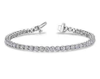 May include: A silver tennis bracelet with a row of round, clear diamonds.