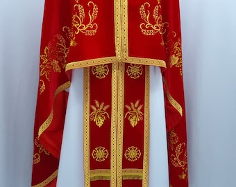 May include: A red liturgical vestment with gold embroidery of wheat and grapes. The vestment has a white undergarment with matching embroidery.