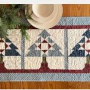 May include: A white ceramic mug with a black handle and the text "But First, Coffee" in a bold, black font. The mug is set against a blurred background, suggesting a cozy setting. The mug appears to be approximately 4 inches tall.