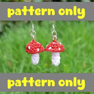 Könnte beinhalten: Handgefertigte Häkel-Pilz-Ohrringe mit roten Kappen, weißen Punkten und weißen Stielen. Der Text "pattern only" ist gelb auf grauem Hintergrund dargestellt. Die Ohrringe sind an silbernen Haken befestigt.