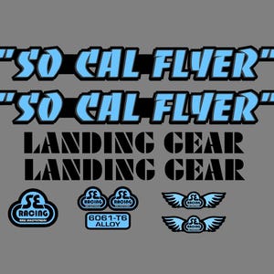 Puede incluir: Un conjunto de pegatinas que incluye el texto SO CAL FLYER en azul claro con bordes negros, LANDING GEAR en negro y varios logotipos de SE RACING, incluyendo emblemas alados y una insignia 6061-T6 ALLOY, sobre un fondo gris sólido.