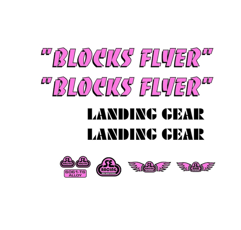 May include: A collection of bicycle decals and logos. The text "BLOCKS FLYER" appears twice in pink, along with "LANDING GEAR" in black. Several small pink logos with wings and the text "SE RACING" are also visible.