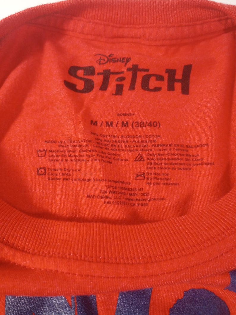 Puede incluir: Camiseta roja con un gr&aacute;fico azul de Stitch e instrucciones de cuidado en la parte posterior. La etiqueta dice "Disney Stitch" y "M/M/M (38/40)".