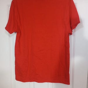 Puede incluir: Una camiseta lisa de color rojo de manga corta. La camiseta est&aacute; hecha de un material suave y c&oacute;modo.