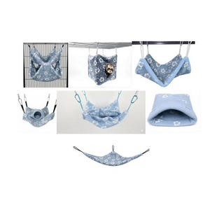 May include: A collection of light blue pet hammocks and hanging pouches featuring a white floral pattern. The set includes various styles of soft fabric beds with metal clips and straps for suspension, designed for small animals to rest and sleep.