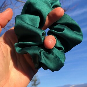 May include: A dark green satin scrunchie for hair.