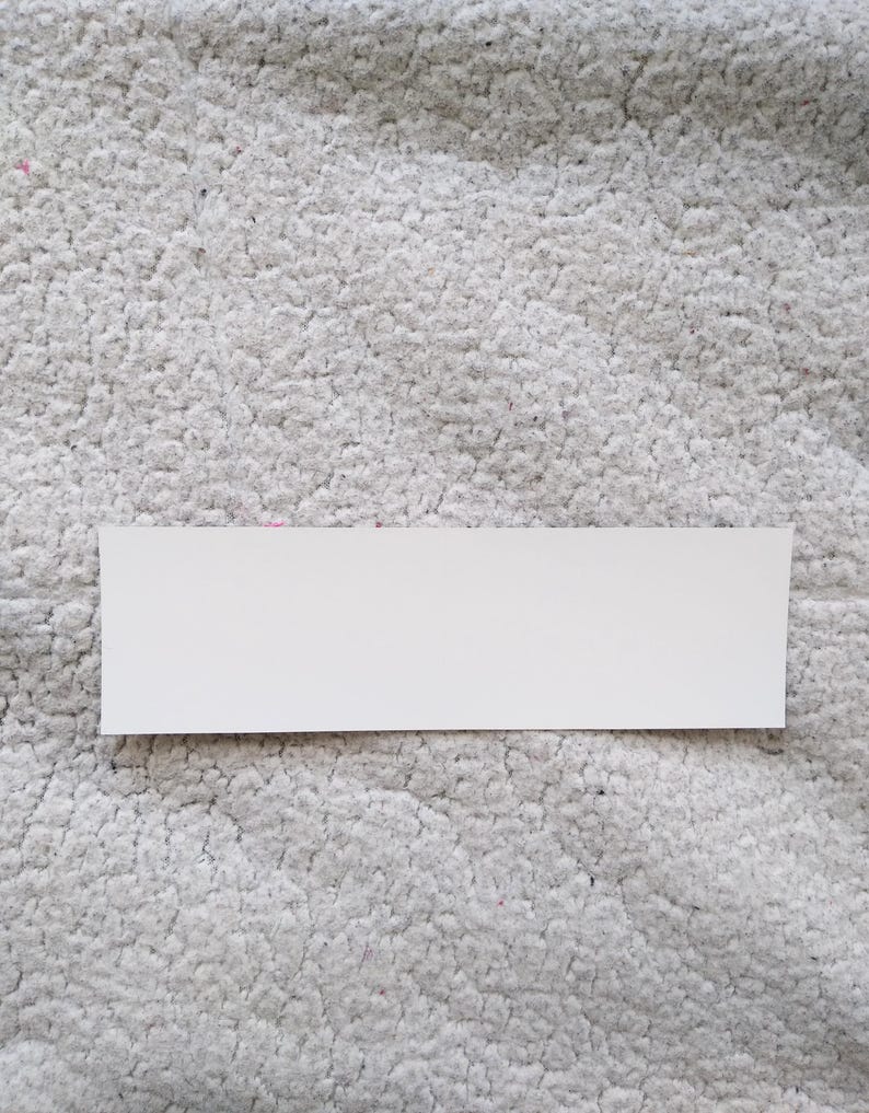 Puede incluir: Una pegatina rectangular blanca con una superficie lisa.