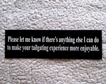 May include: Black sign with white text that reads: "Please let me know if there's anything else I can do to make your tailgating experience more enjoyable."