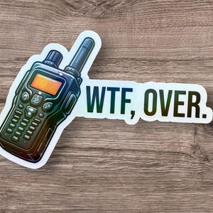 May include: A black and white sticker with a cartoon illustration of a walkie talkie and the text "WTF, OVER."