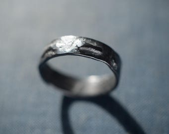 May include: A silver band ring with a hammered texture.
