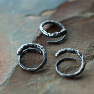 May include: Three silver rings with a textured, rough finish. The rings are open and have a simple, minimalist design.