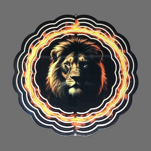 May include: A metal wind spinner with a lion's face in the center. The lion is surrounded by a ring of flames. The wind spinner is black with orange and yellow accents.