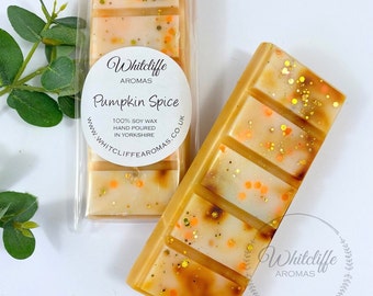 May include: Two wax melts in clear packaging. The wax melts are a light brown color with orange and gold glitter. The wax melts are labeled "Whitcliffe Aromas Pumpkin Spice 100% Soy Wax Hand Poured in Yorkshire www.whitcliffe aromas.co.uk"