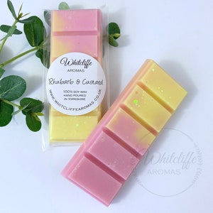 May include: Two wax melts, one pink and yellow and the other yellow and white, with the text "Whitcliffe Aromas Rhubarb & Custard 100% Soy Wax Hand Poured in Yorkshire www.whitcliffe aromas.co.uk"