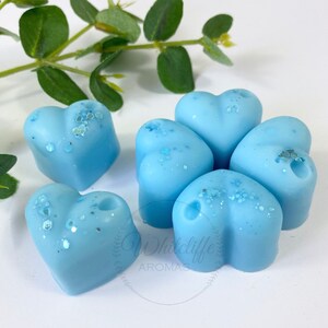 May include: Six light blue heart-shaped wax melts with a glittery finish.