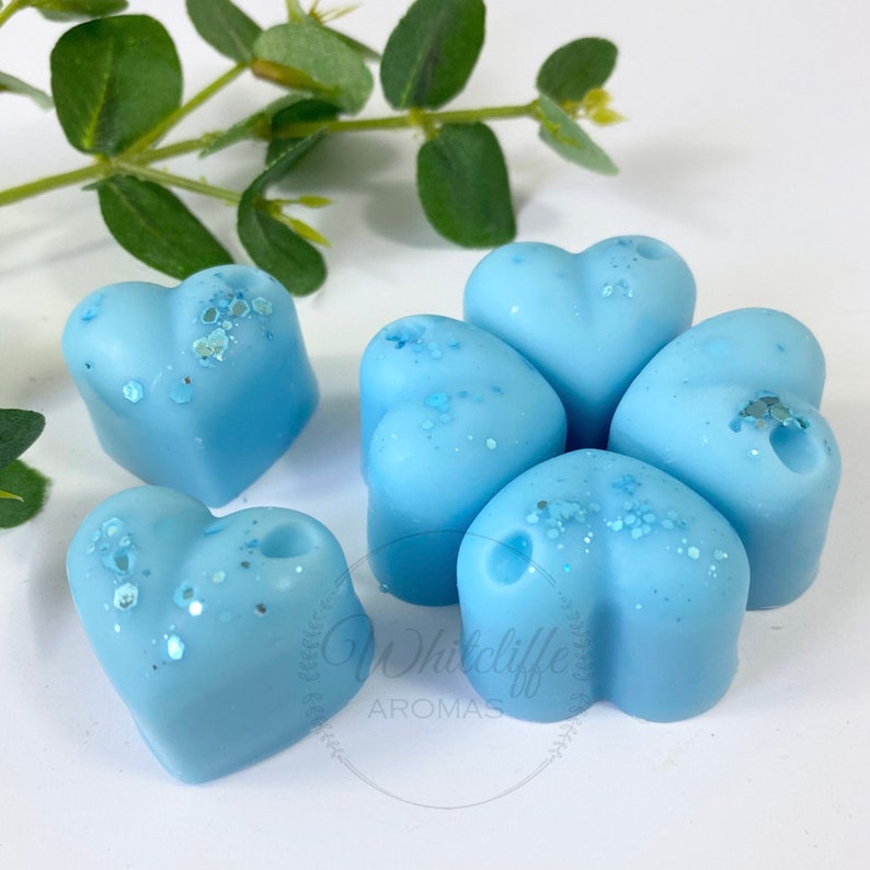 May include: Six light blue heart-shaped wax melts with a glittery finish.