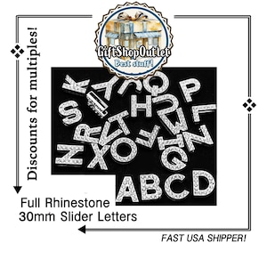 May include: A set of 30mm silver rhinestone slider letters. The letters are arranged in a random order, with some letters overlapping. The letters are on a black background. The text "Full Rhinestone 30mm Slider Letters" is below the letters.