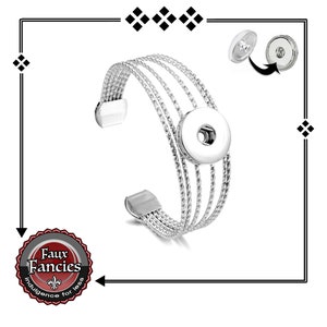 May include: Silver bracelet with a snap button closure. The bracelet has five strands of braided metal.