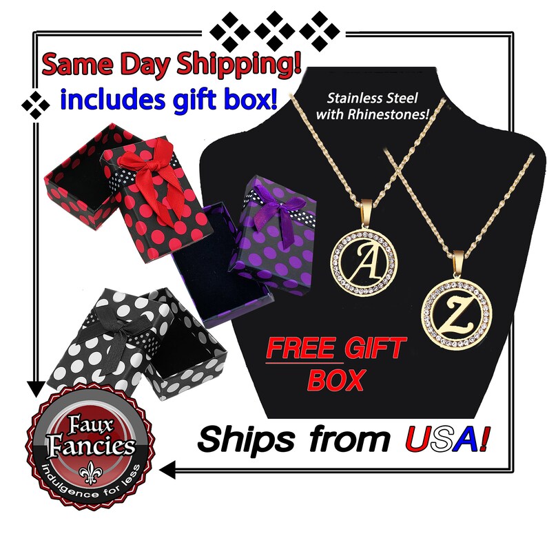 May include: Two gold-tone stainless steel necklaces featuring circular pendants with rhinestones and the letters A and Z. The set includes three patterned gift boxes in red, purple, and white with black polka dots and ribbon bows.
