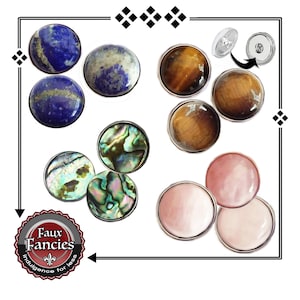 May include: Assortment of faux gem snap buttons in various colors and patterns, including blue, brown, green, and pink. The buttons are designed to be used for clothing and crafts. The text "Faux Fancies Indulgence for less" is visible on a sticker.