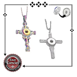 May include: Two cross pendant necklaces. One is iridescent with a central snap and decorative accents. The other is silver-toned, adorned with clear crystals and a white snap. Both hang on delicate chains.