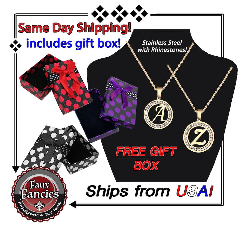 May include: Two gold-tone stainless steel necklaces featuring circular pendants with rhinestones and the letters A and Z. The set includes three patterned gift boxes in red, purple, and white with black polka dots and ribbon bows.