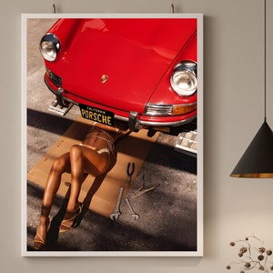 May include: A red vintage Porsche with a California license plate that reads "PORSCHE" is being worked on. A person is lying under the car, wearing a white bikini top and a pair of yellow sandals.