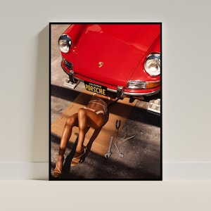 May include: A red vintage Porsche car is lifted up on a jack, with a person lying underneath it. The car has a California license plate that reads "PORSCHE".