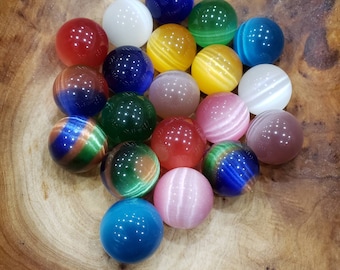 May include: A collection of 18 smooth, round, colorful marbles in a wooden bowl. The marbles are made of glass and have a variety of colors, including blue, green, red, yellow, and white.