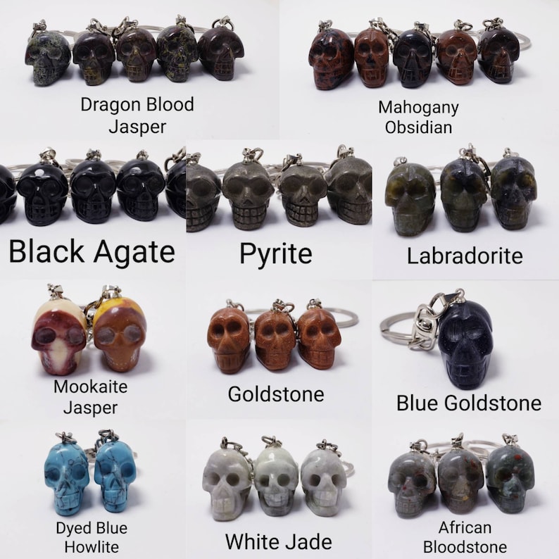 May include: A collection of 10 different skull-shaped keychains made from various types of stones, including Dragon Blood Jasper, Mahogany Obsidian, Black Agate, Pyrite, Labradorite, Mookaite Jasper, Goldstone, Blue Goldstone, Dyed Blue Howlite, and White Jade. Each keychain features a detailed skull carving and a silver key ring.