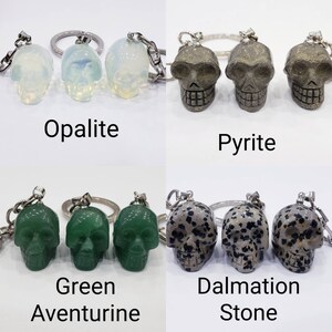 May include: Three sets of three crystal skull keychains. The first set is opalite, the second is pyrite, the third is green aventurine, and the fourth is dalmatian stone.