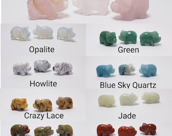 May include: A collection of ten small pig figurines carved from different types of stone, including opalite, green, howlite, blue sky quartz, crazy lace, jade, unakite, and red jasper.