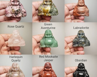 Puede incluir: Nueve tallas de piedra diferentes de un Buda sonriente, cada una tallada en un tipo de piedra diferente, incluyendo rodonita, jaspe oceánico, jaspe rojo, cuarzo rosa, aventurina verde, labradorita, cuarzo arlequín, jaspe rojo mookaite y obsidiana.
