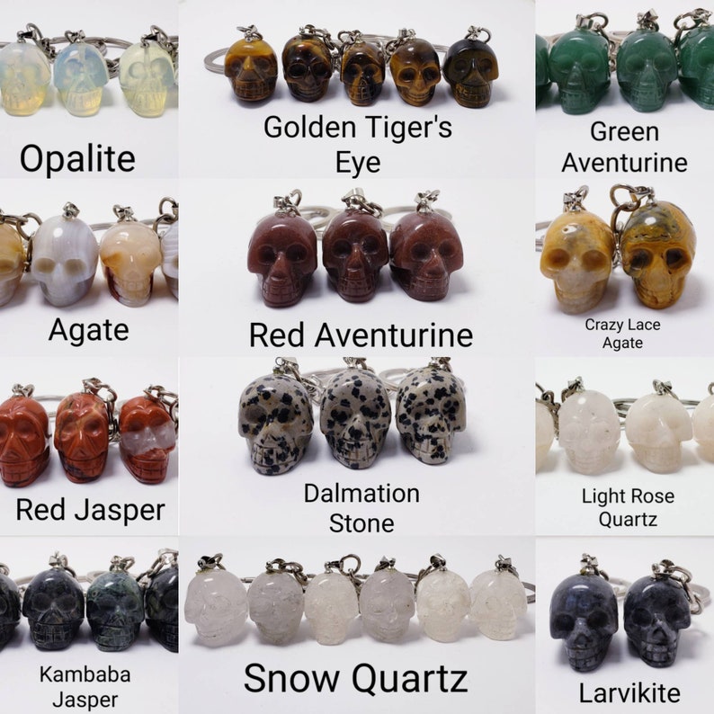 May include: A set of 10 different gemstone skull keychains. The skulls are made of various stones, including agate, aventurine, jasper, opalite, quartz, and tiger's eye. Each keychain features a silver key ring.