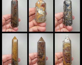 Puede incluir: Seis diferentes torres de cristal pulido multicolores. Las torres tienen aproximadamente 10 cm de altura y presentan una variedad de colores, incluyendo marrón, rojo, amarillo y negro.