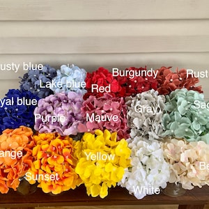 May include: Assortment of 14 faux hydrangea flower heads in various colors, including dusty blue, lake blue, royal blue, purple, mauve, red, burgundy, rust, gray, sage, orange, sunset, yellow, white, and beige.