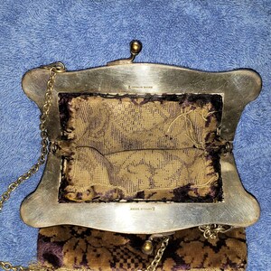 Peut inclure: Un sac &agrave; main vintage en argent et or avec une bandouli&egrave;re en cha&icirc;ne et une doublure &agrave; motif floral. Le sac porte les inscriptions "AMERICAN SILVER" et "MADE IN ENGLAND" &agrave; l'int&eacute;rieur.