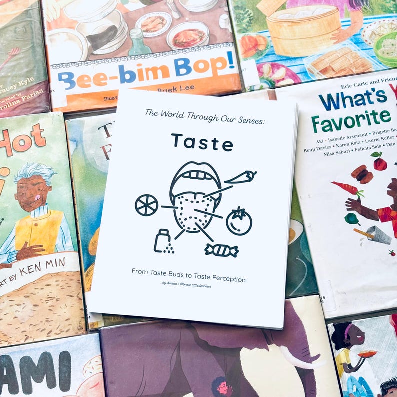 May include: A collection of children's books with colorful covers. The central book, titled "Taste," features a black and white illustration of a tongue with food icons. Other titles include "Bee-bim Bop!" and "What's Your Favorite?"