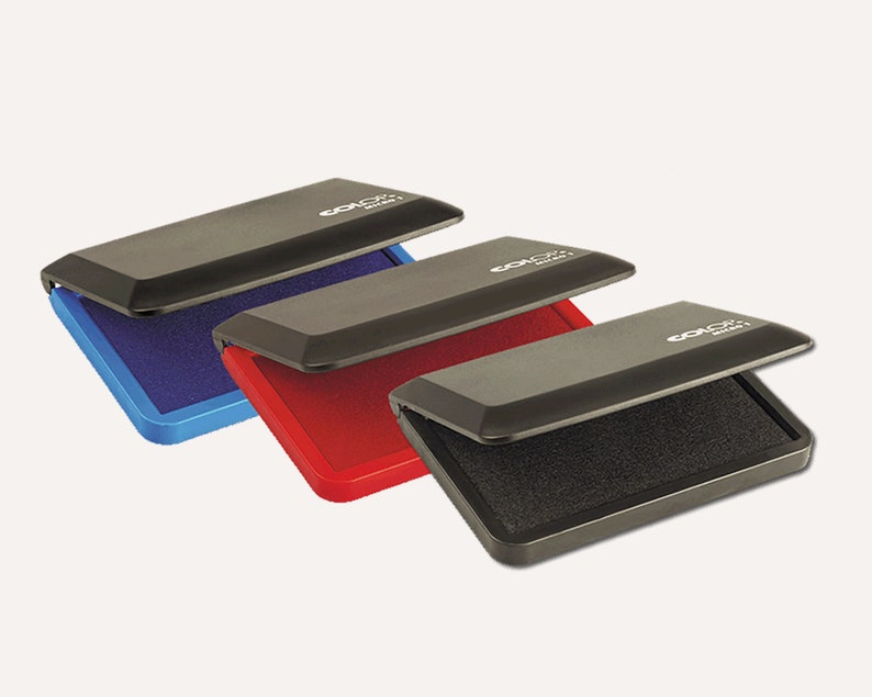 May include: Three ink pads with black plastic cases and different colored ink pads. The ink pads are blue, red, and black.