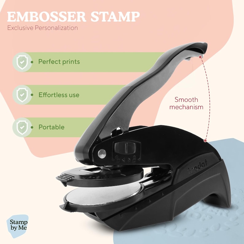 May include: Black embosser stamp with a smooth mechanism and a round, silver-colored plate. The stamp is labeled "rodat" and has a handle that lifts up to reveal the plate. The stamp is on a light blue surface.