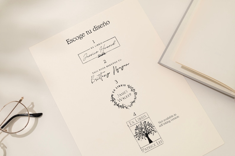 May include: A sheet of paper with four different black ink stamp designs for books. The text "Escoge tu dise&ntilde;o" is at the top. Designs include names and the words "Ex Libris". A pair of glasses is in the lower left corner.